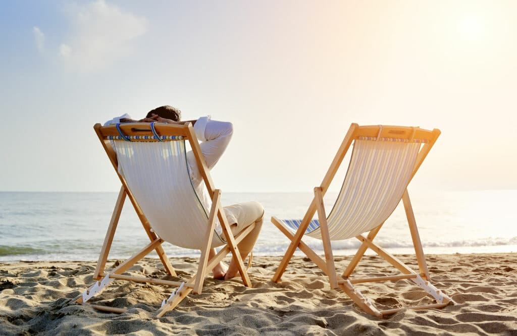 Vad är D-vitamin bra för? Man som solar på stranden.