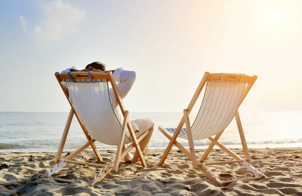 Vad är D-vitamin bra för? Man som solar på stranden.